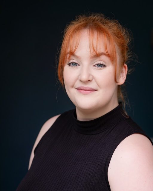 Professional headshot of Jess Latham against a dark background